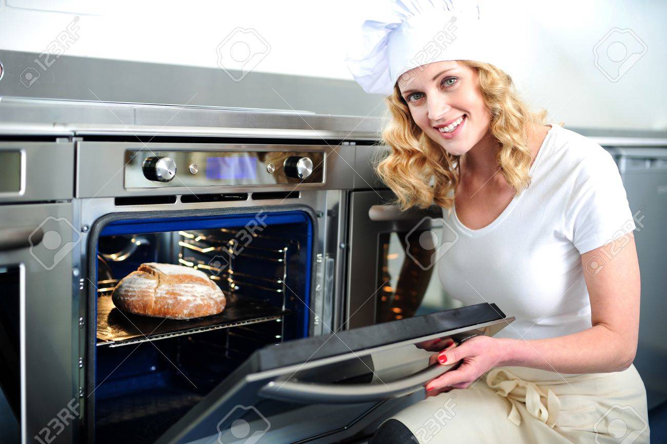 Pretty Baker Opening An Oven Door Ready To Pull Out Baked Bread Stock Photo Picture And Royalty Free Image Image 14200287