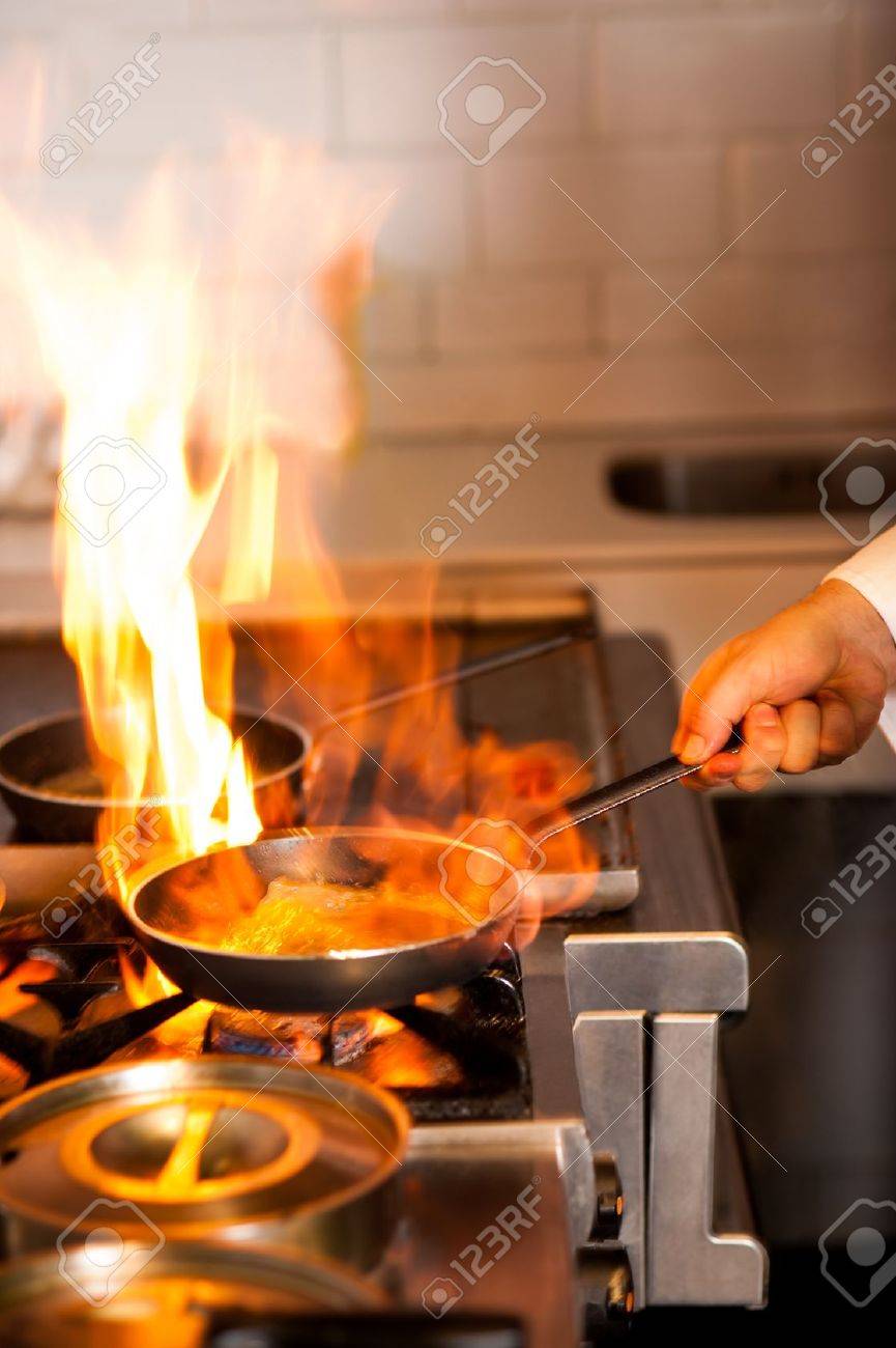 シェフの台所用レンジ上のフライパンの炎と料理します の写真素材 画像素材 Image