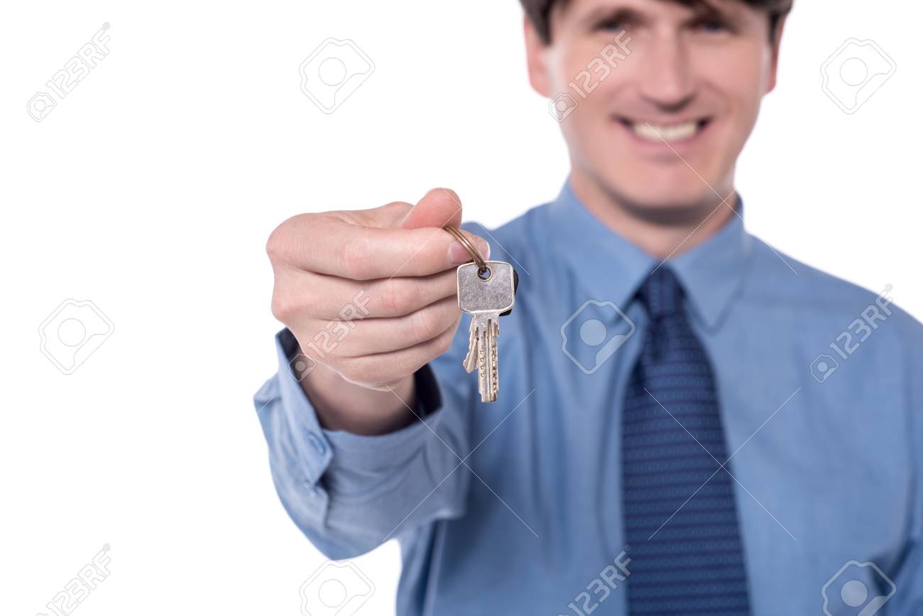Blurred image of realtor offering house key. - 60379415 Blurred image of realtor offering house key. - 60379415