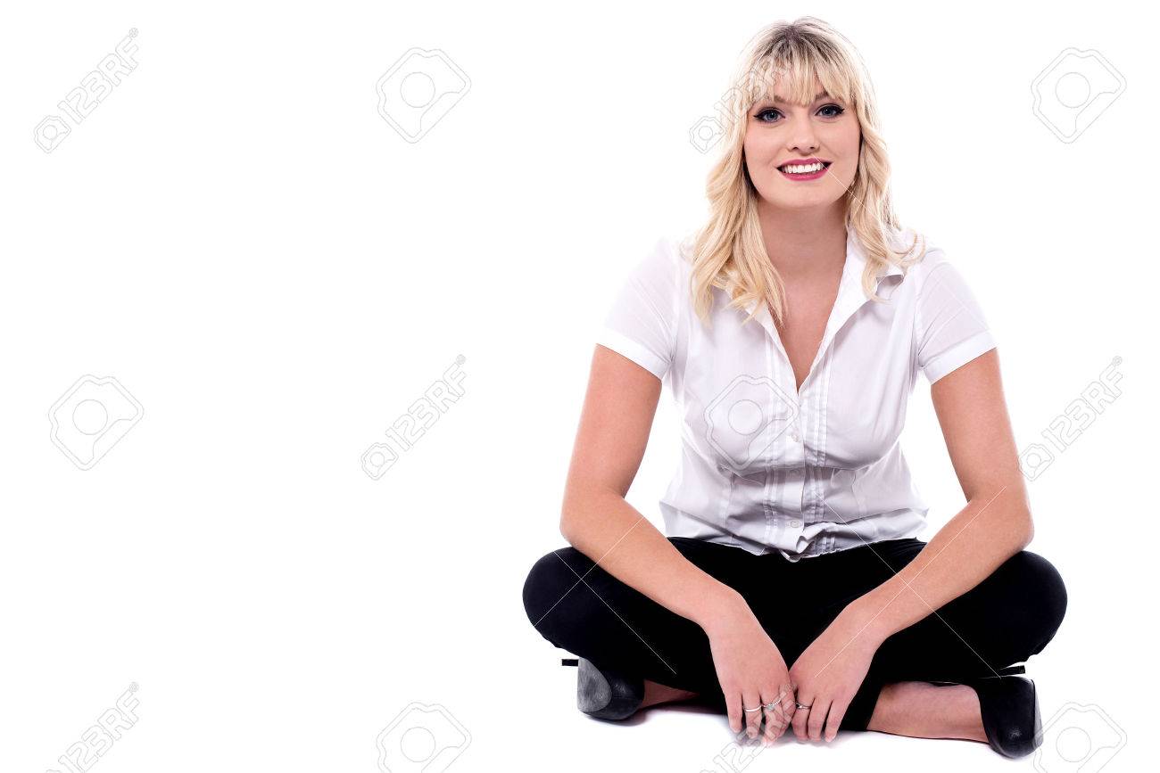Casual young woman sitting with crossed legs. - 60380251 Casual young woman sitting with crossed legs. - 60380251