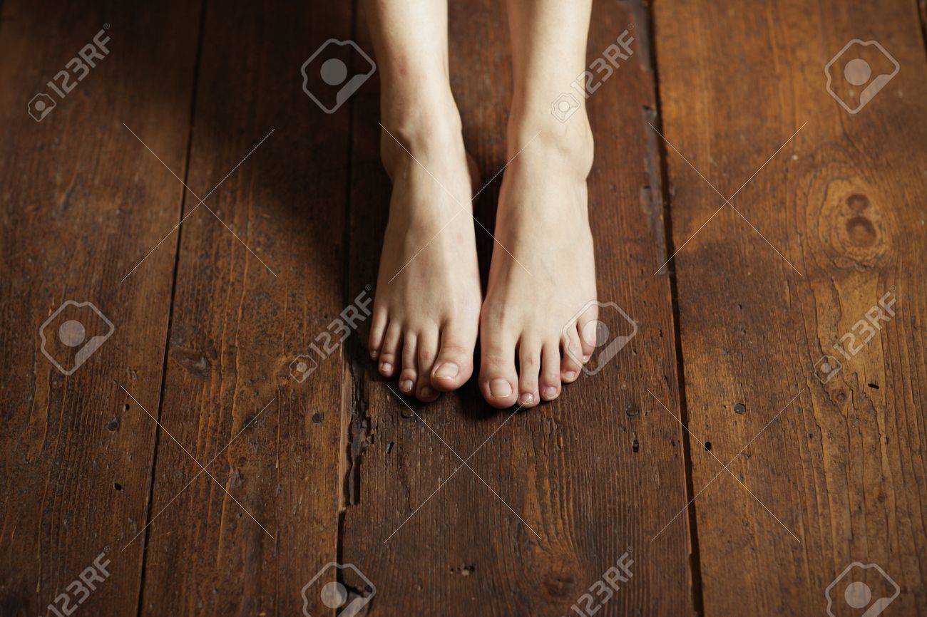 Cropped Image Of Female Bare Feet On A Wooden Floor Stock Photo