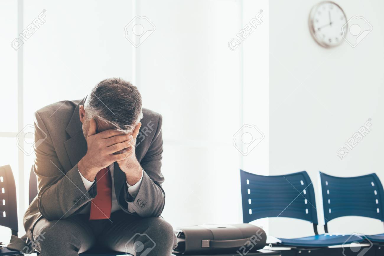 Desperate businessman in the waiting room with head in hands, he is waiting for a job interview; unemployment and business failure concept - 84116258 Desperate businessman in the waiting room with head in hands, he is waiting for a job interview; unemployment and business failure concept - 84116258
