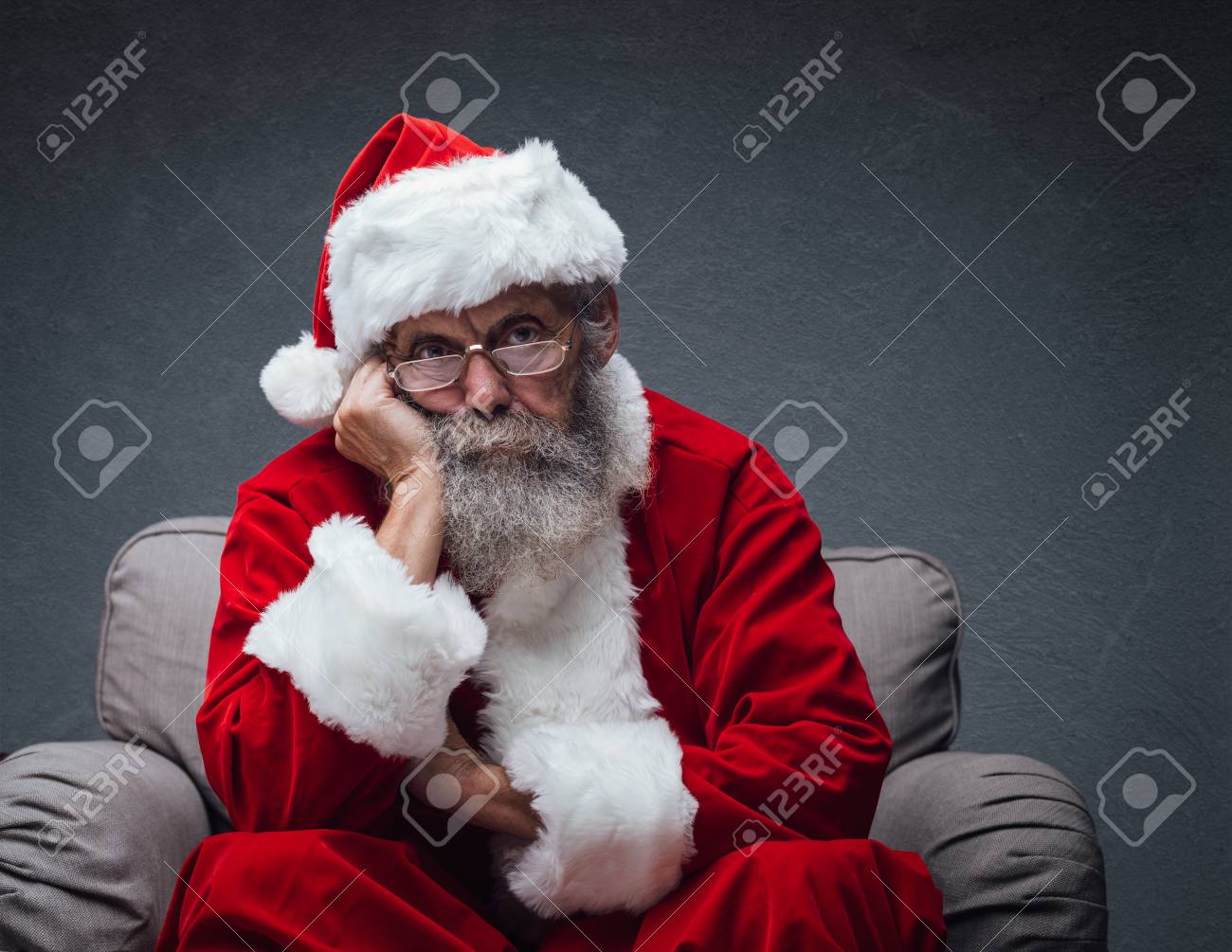 Lazy bored Santa Claus leaning on his hand and relaxing on the armchair, he is waiting for Christmas - 89097221 Lazy bored Santa Claus leaning on his hand and relaxing on the armchair, he is waiting for Christmas - 89097221