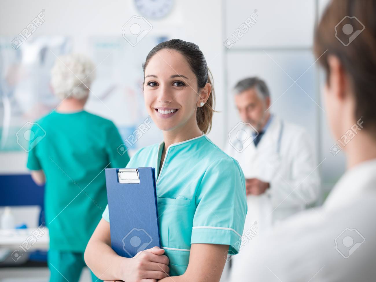 Young female medical student working at the hospital and medical staff, she is holding medical records - 96977320 Young female medical student working at the hospital and medical staff, she is holding medical records - 96977320