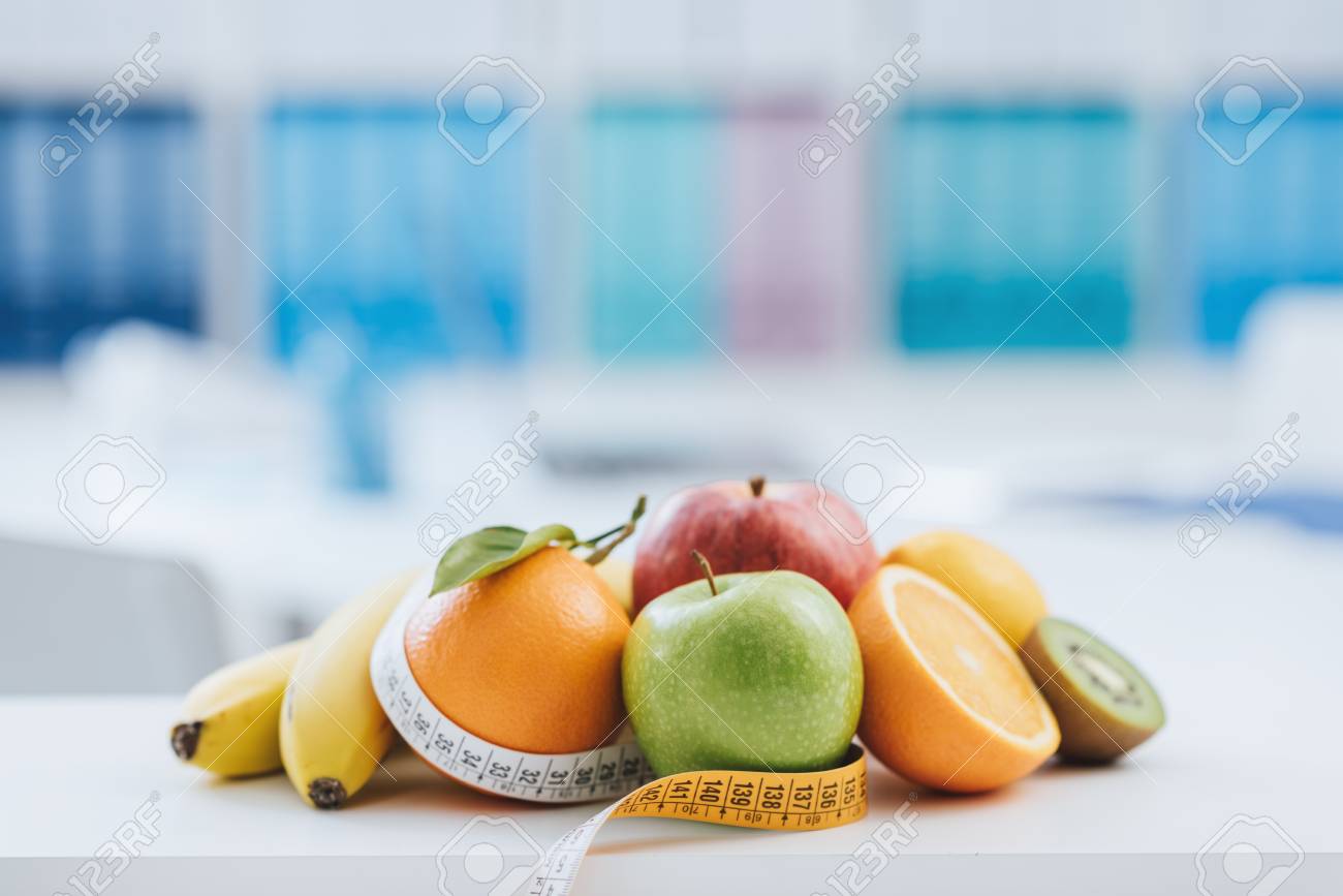 fresh healthy fruits and tape measure in the nutritionist office nutritionist office