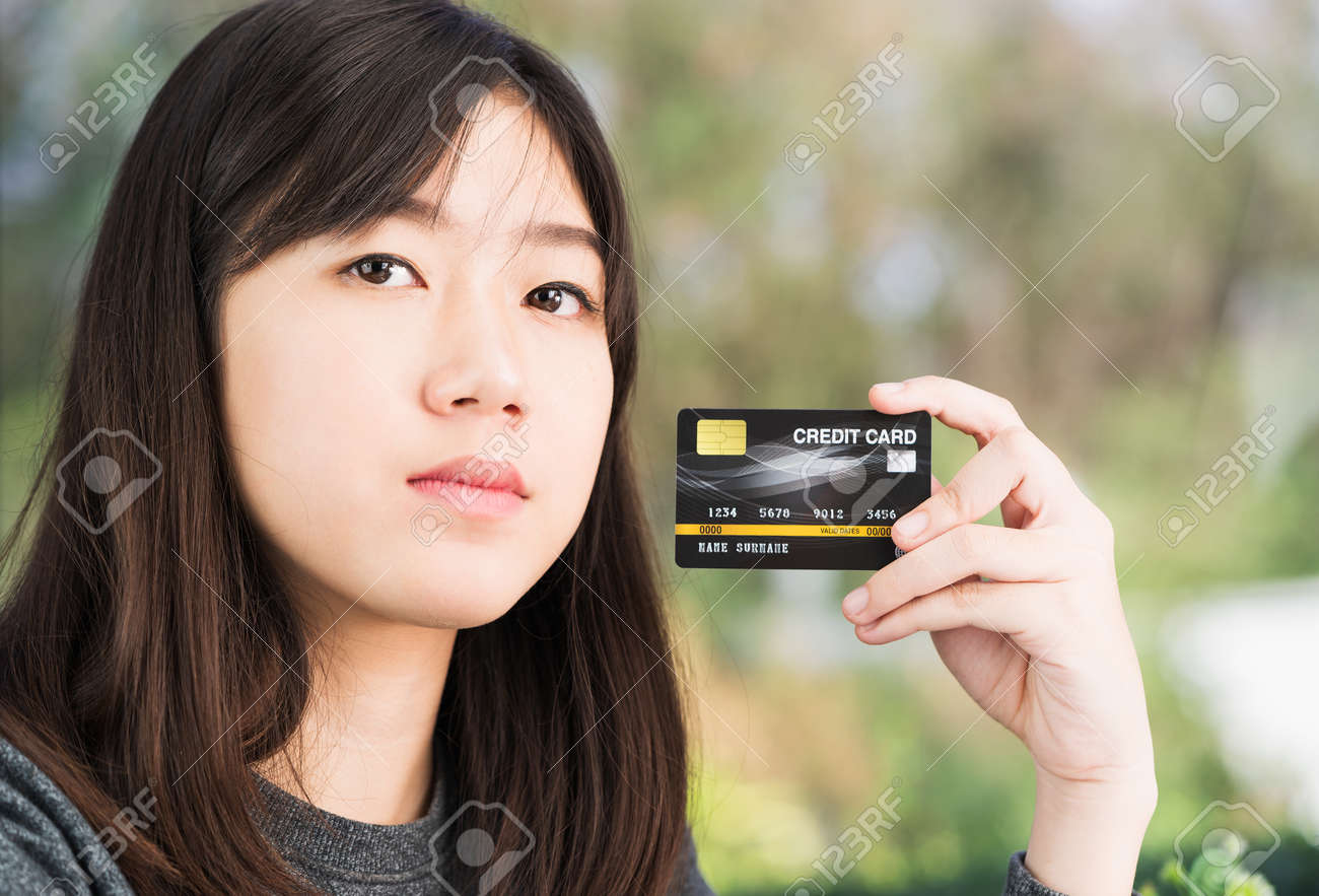 Close up young woman holding credit card. Online shopping concept - 140754983 Close up young woman holding credit card. Online shopping concept - 140754983