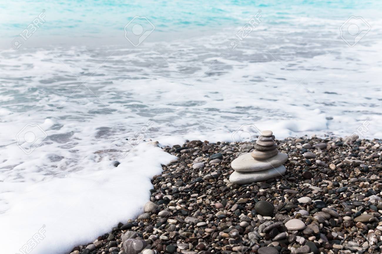 the pyramid of pebbles on the beach stock photo picture and
