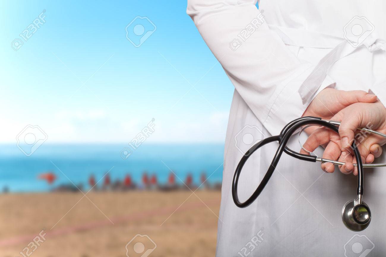 The doctor put his hands with stethoscope behind his back on a blurred background. - 54369405 The doctor put his hands with stethoscope behind his back on a blurred background. - 54369405