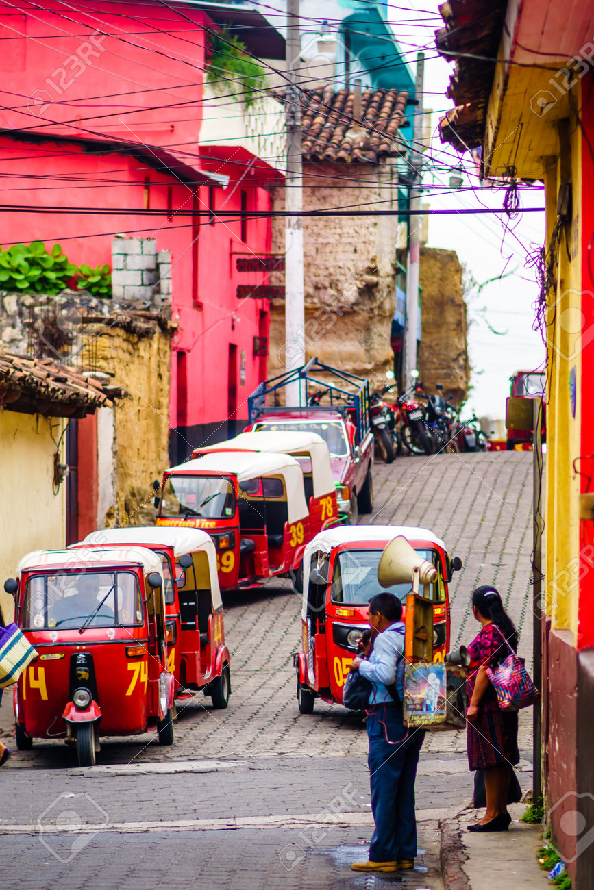 Chichicastenango, Guatemala on 2th May 2016: View on Indigenous person informing people with louspeaker in a street full of Tuk Tuk - 142308262 Chichicastenango, Guatemala on 2th May 2016: View on Indigenous person informing people with louspeaker in a street full of Tuk Tuk - 142308262