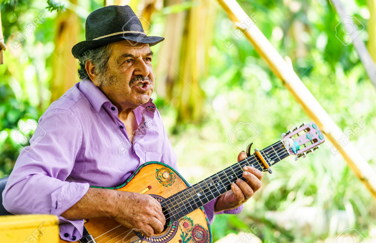 Jardin, COLOMBIA - March 25, 2019 - Indigenous men playing guitar in the village of Jardin - 142308866 Jardin, COLOMBIA - March 25, 2019 - Indigenous men playing guitar in the village of Jardin - 142308866