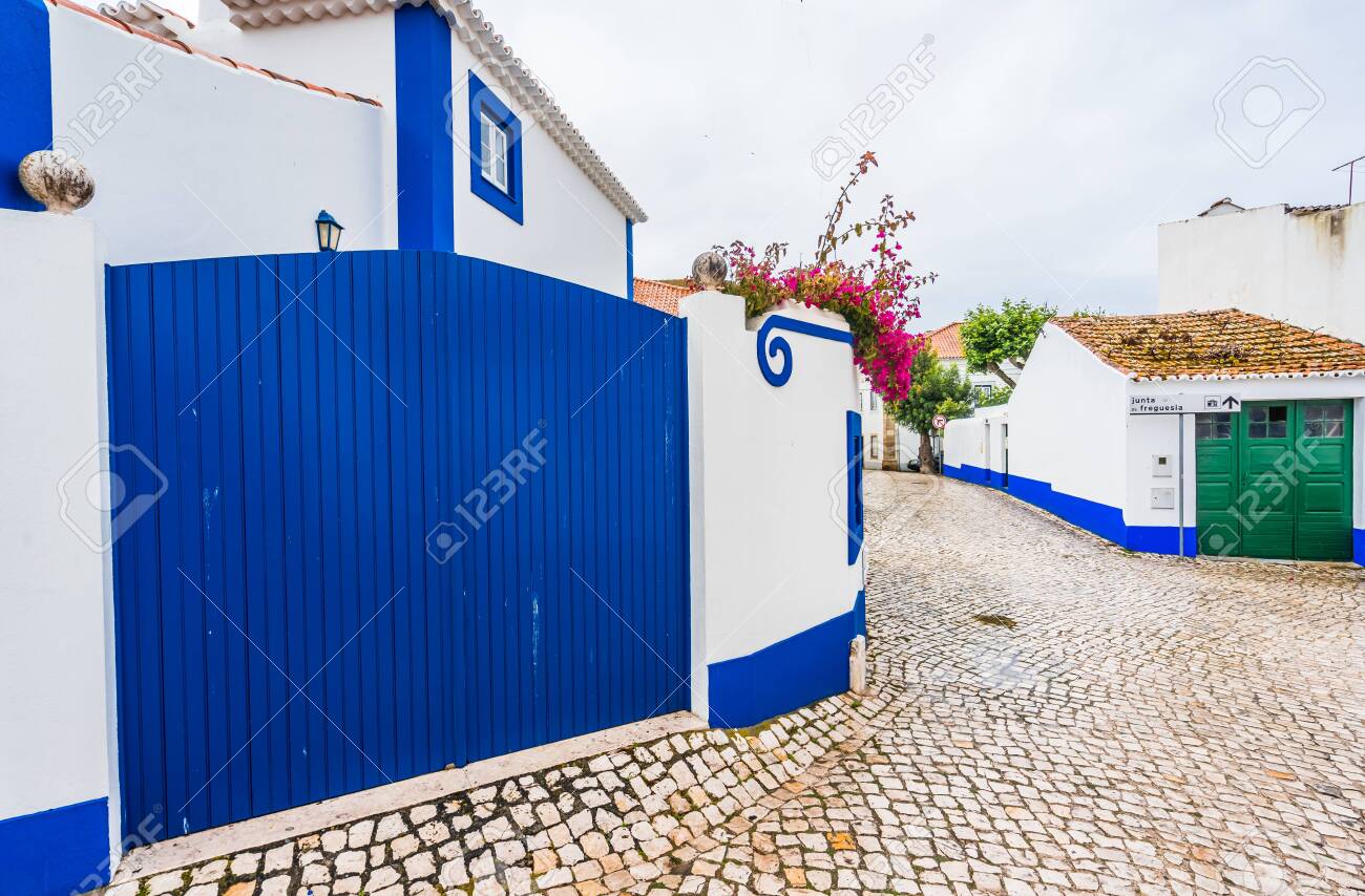 View in the streets of Ericeira, traditional white houses with blue stripes, Portugal - 144070054 View in the streets of Ericeira, traditional white houses with blue stripes, Portugal - 144070054