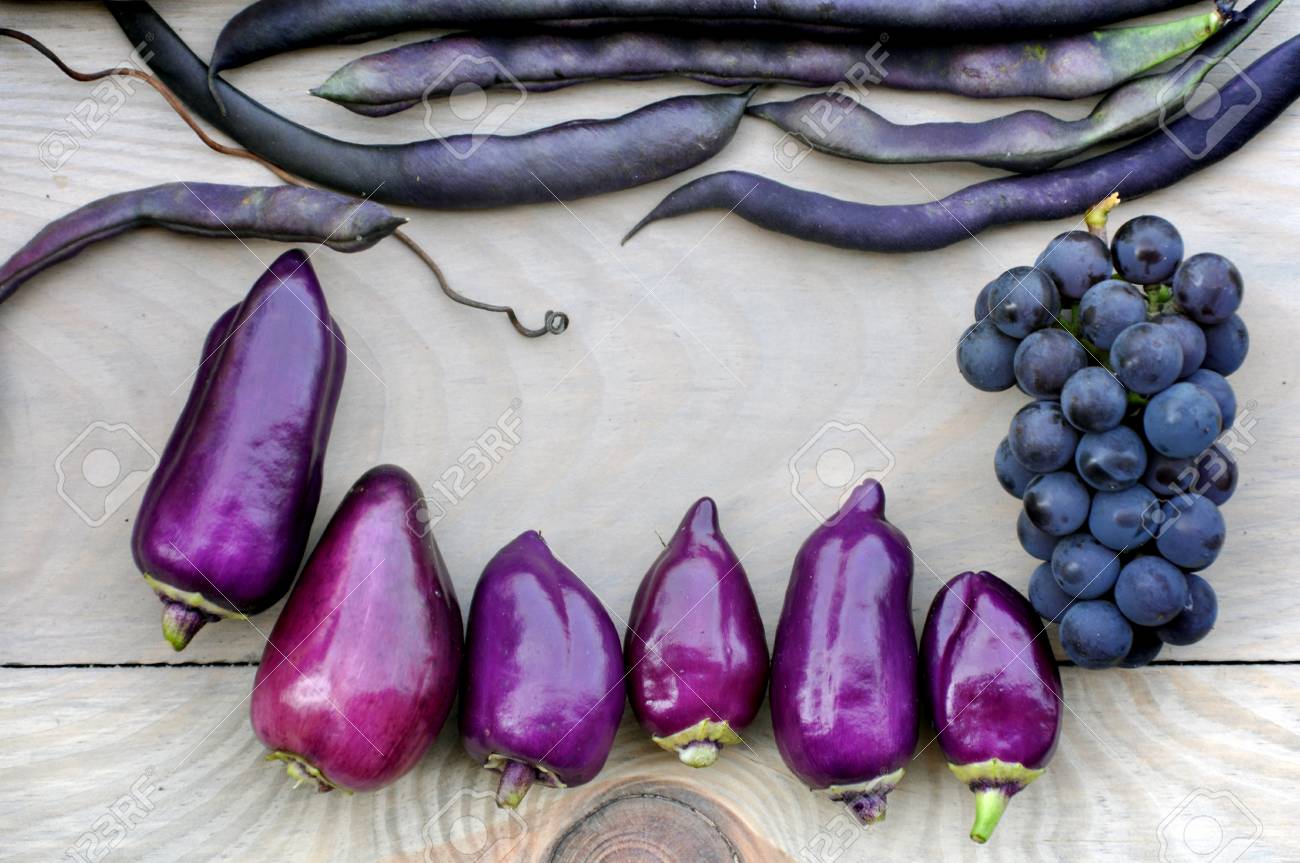 秋の食べ物の背景 明るい木製の背景に紫ピーマン 紫豆 青ブドウ センター内の空き領域 の写真素材 画像素材 Image 7291