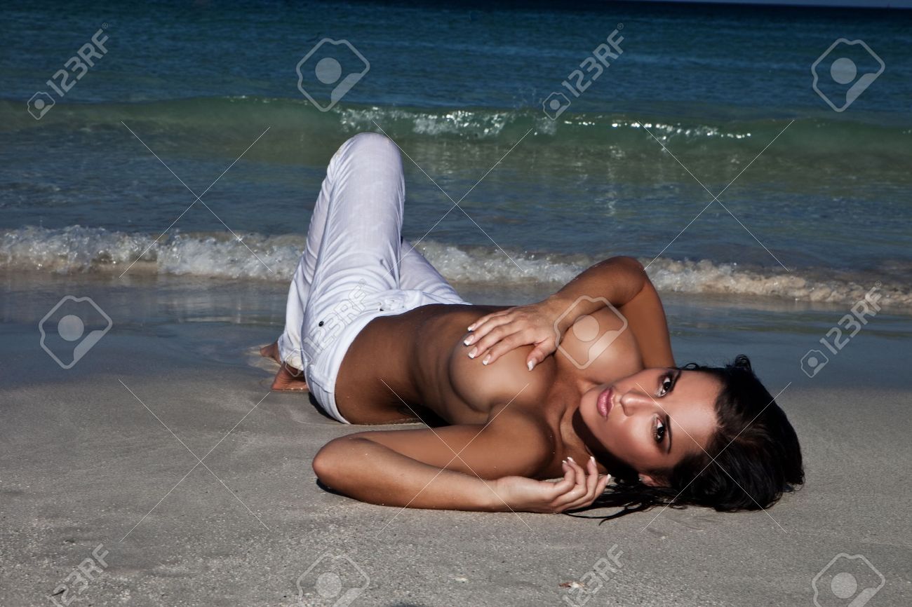 Topless Femme Sexy Avec De Gros Seins En Partie Caché Par Son Bras Allongé  Sur Une Plage En Bord De Mer. Banque D'Images et Photos Libres De Droits.  Image 12589509