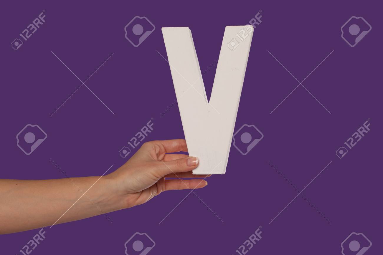 Mano Femenina Sosteniendo La V Mayuscula Mayusculas Aisladas Sobre Un Fondo Morado Conceptual Del Alfabeto La Escritura La Literatura Y El Tipo De Letra Fotos Retratos Imagenes Y Fotografia De Archivo Libres