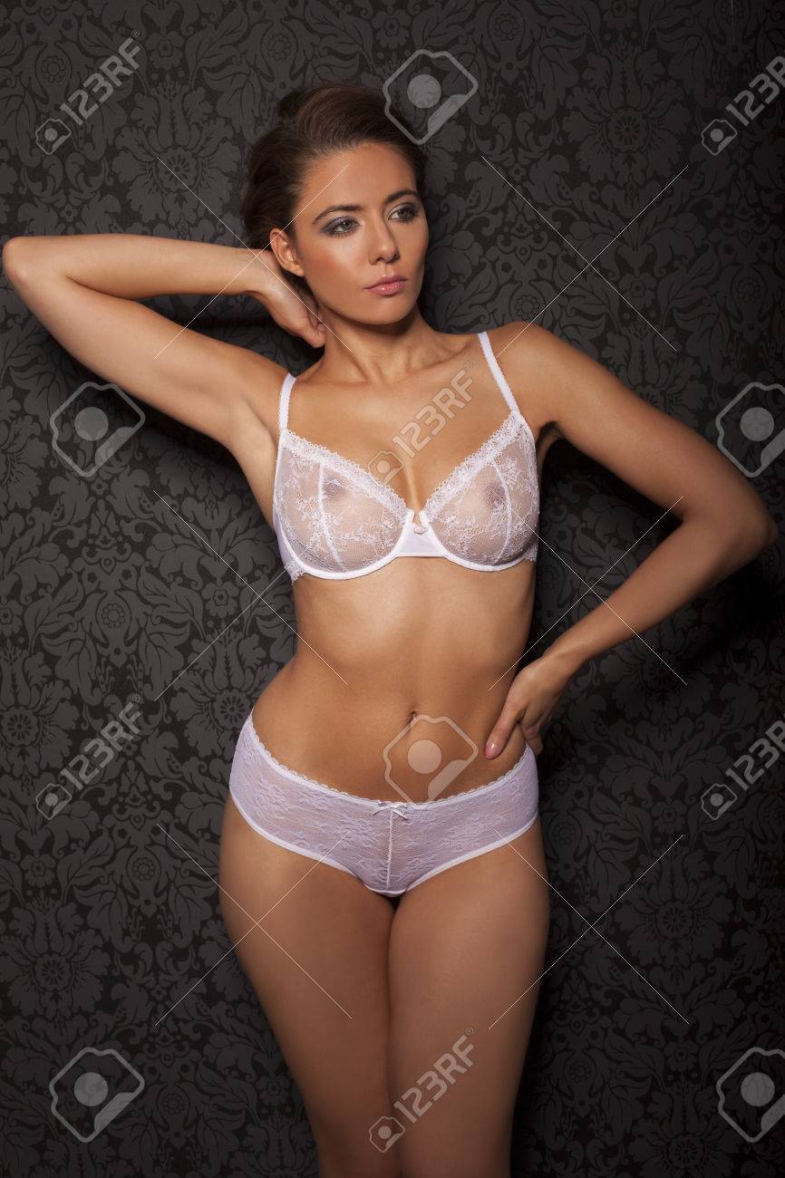 Confident Sexy Busty Young Woman In White Lingerie Posing With Her Arms  Raised Looking Away Pensively To The Side Stock Photo, Picture and Royalty  Free Image. Image 25853330.