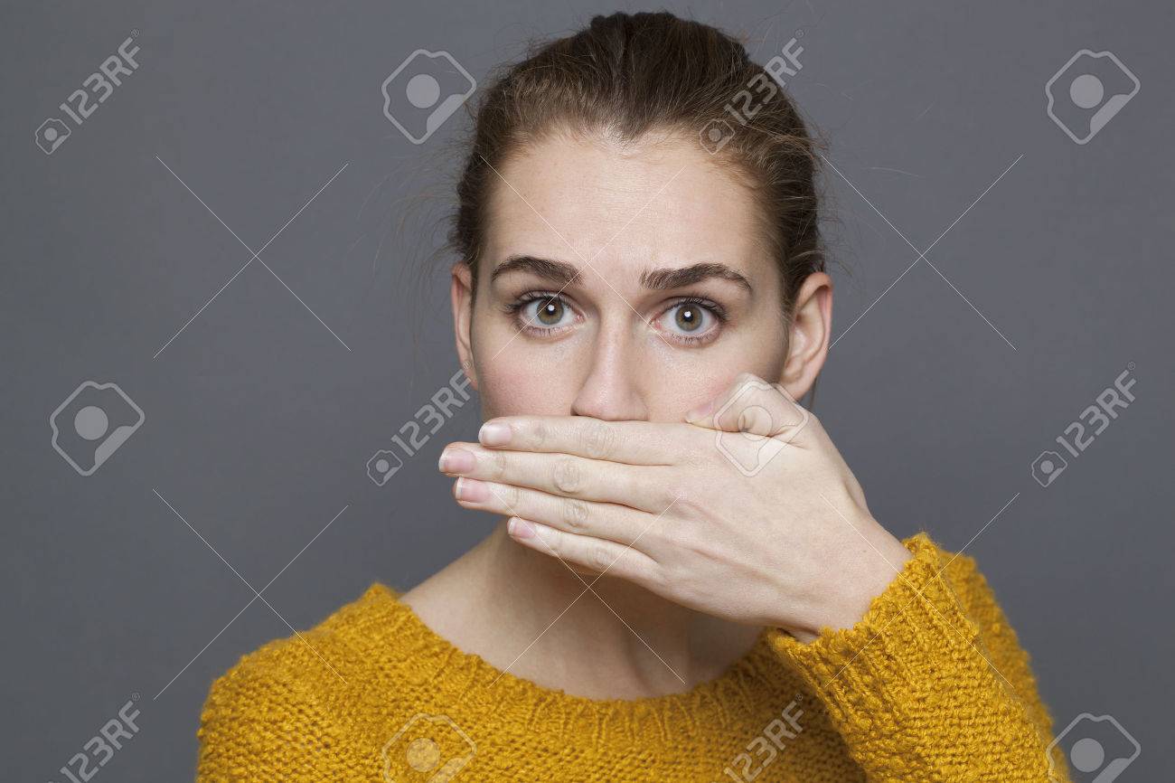 否定的な感情の概念 の肖像画を驚かせた美しい 代女の子の口臭やタブー スタジオのための彼女の口を覆っている灰色の背景で撮影 の写真素材 画像素材 Image