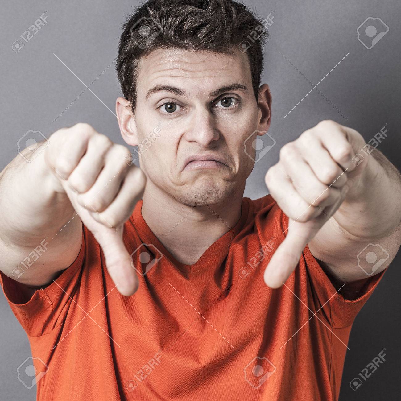 Schmollen Junge Sportliche Mann Der Seine Abneigung Und Enttauschung Mit Den Daumen Nach Unten In Den Vordergrund Zeigt Nahaufnahme Von Seiner Schmollend Gesicht Und Verlierer Zeichen Mit Strukturiertem Effekte Lizenzfreie Fotos Bilder