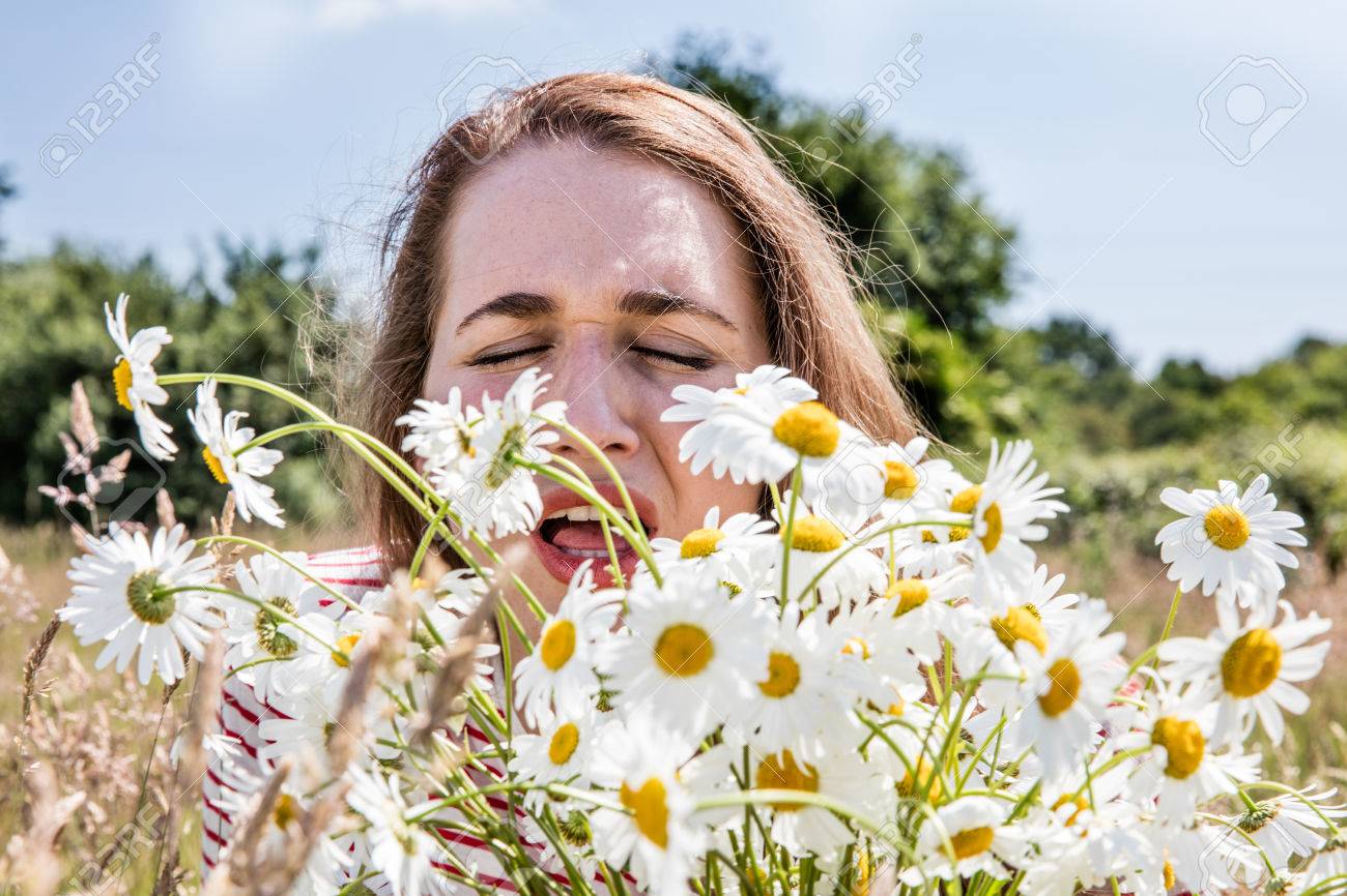 花粉症アレルギー 花粉病くしゃみをし 自然な夏の日光の花の新鮮な花束の香りを持つ若い女性 の写真素材 画像素材 Image