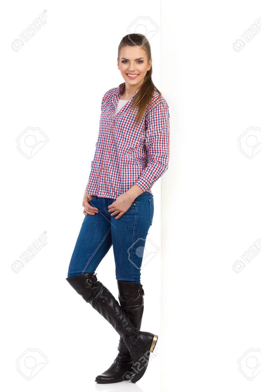 Mujer Joven En Pantalones Vaqueros, Botas Negras Y Camisa De Los pantalones vaqueros y las botas de mujer Fotografía de