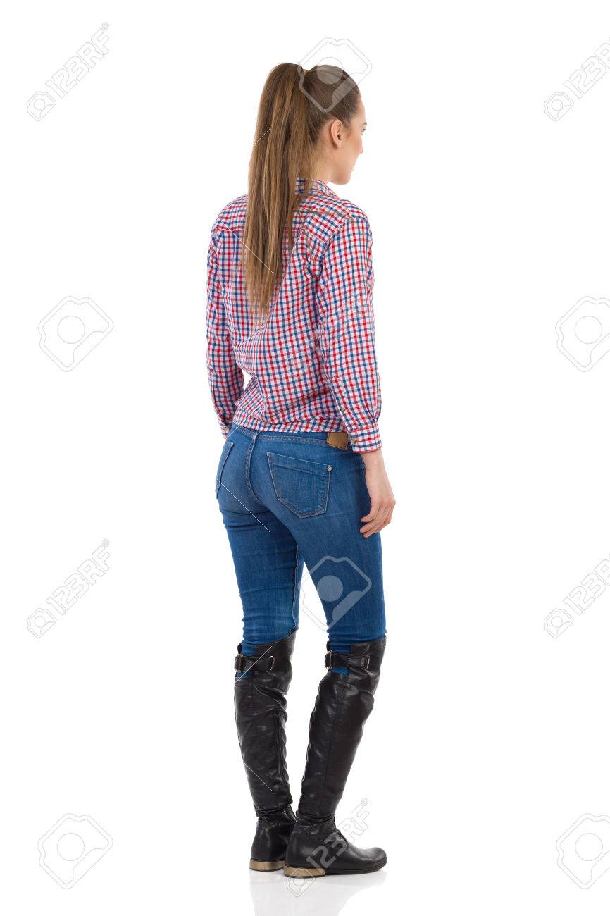 Mujer Joven De Pie En Pantalones Vaqueros, Botas Negras Y Los pantalones vaqueros y las botas de mujer Fotografía de