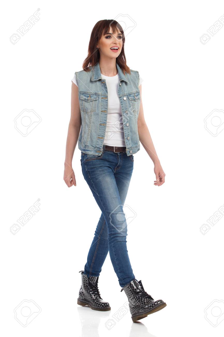 La Mujer Joven En Chaleco De Los Pantalones Vaqueros Y Botas Los pantalones vaqueros y las botas de mujer Fotografía de