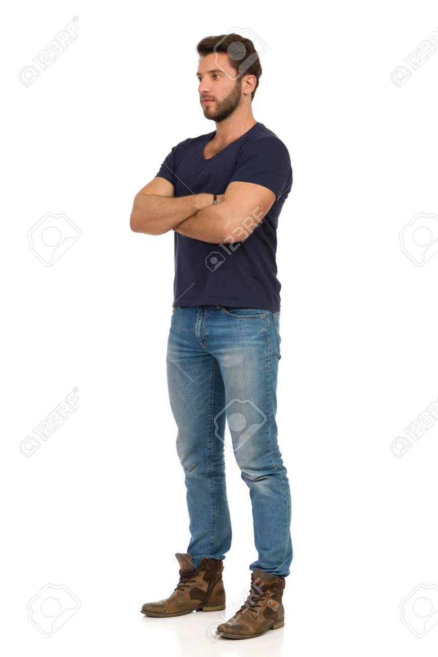 Serious handsome man in jeans, boots and blue t-shirt is standing with arms crossed and looking away. Full length studio shot isolated on white. - 125166568 Serious handsome man in jeans, boots and blue t-shirt is standing with arms crossed and looking away. Full length studio shot isolated on white. - 125166568