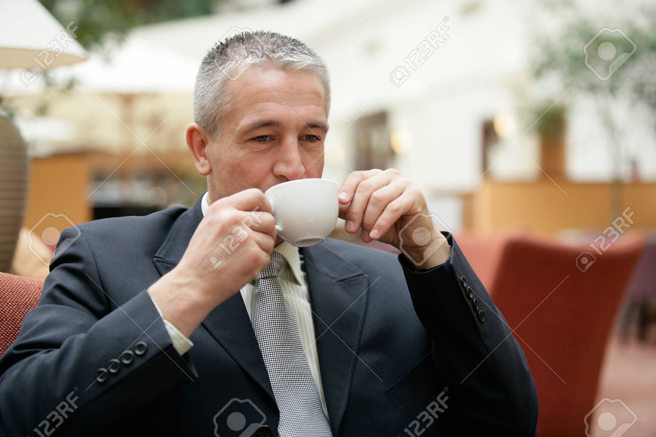 レストランに座ってコーヒーのスーツを飲む成熟した白髪のハンサムなビジネスマン の写真素材 画像素材 Image