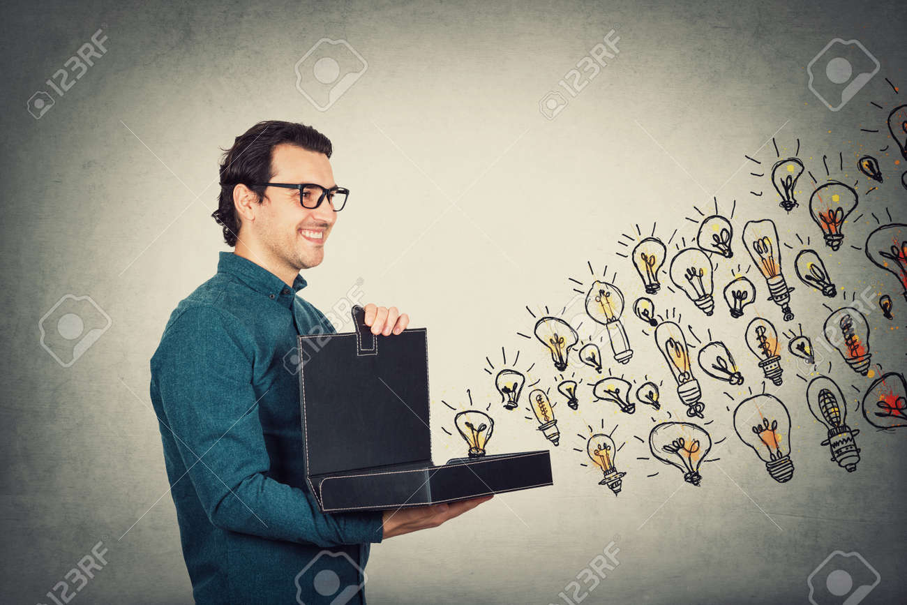 Businessman opens his briefcase filled with brilliant ideas as different lightbulbs comes out of the box. Ingenious boss shows the business portfolio, shares his creativity and genius with employees. - 154953363 Businessman opens his briefcase filled with brilliant ideas as different lightbulbs comes out of the box. Ingenious boss shows the business portfolio, shares his creativity and genius with employees. - 154953363