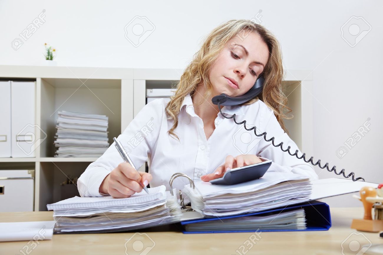 Busy Business Woman On The Phone Taking Notes And Using A ...