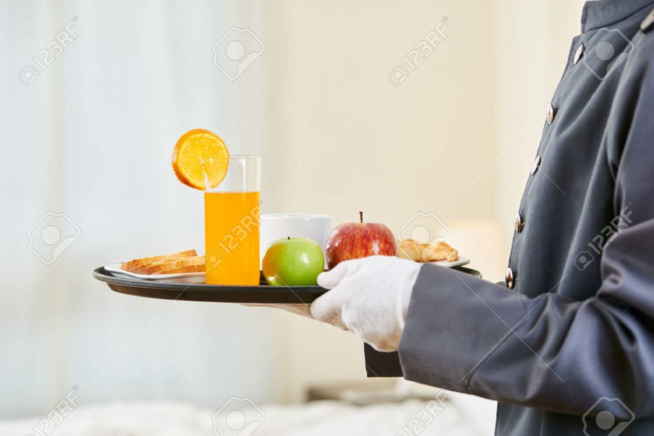 Room service bringing healthy breakfast with orange juice and fruits - 60524209 Room service bringing healthy breakfast with orange juice and fruits - 60524209
