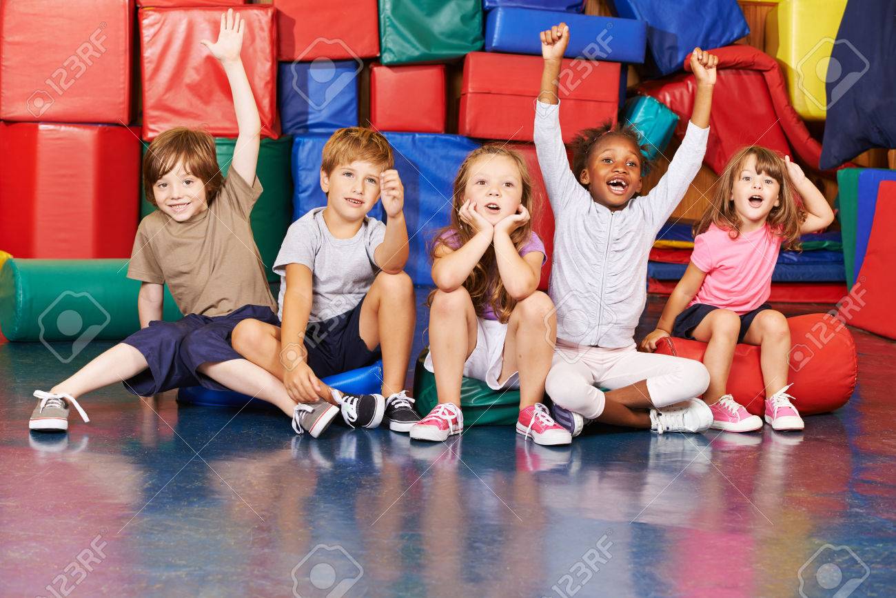 Children cheering together after victory in gym of a pre school - 61079666 Children cheering together after victory in gym of a pre school - 61079666