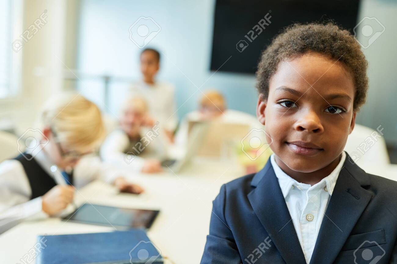 African child as a businessman or entrepreneur in front of his business team - 135173221 African child as a businessman or entrepreneur in front of his business team - 135173221