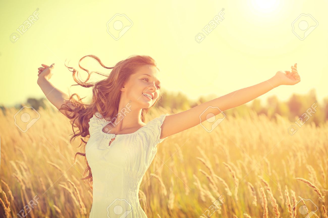 Beauty happy girl with blowing hair enjoying nature on the field - 34792225 Beauty happy girl with blowing hair enjoying nature on the field - 34792225