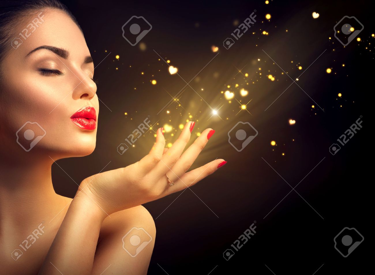 Beauty young woman blowing magic dust with golden hearts - 51755923 Beauty young woman blowing magic dust with golden hearts - 51755923
