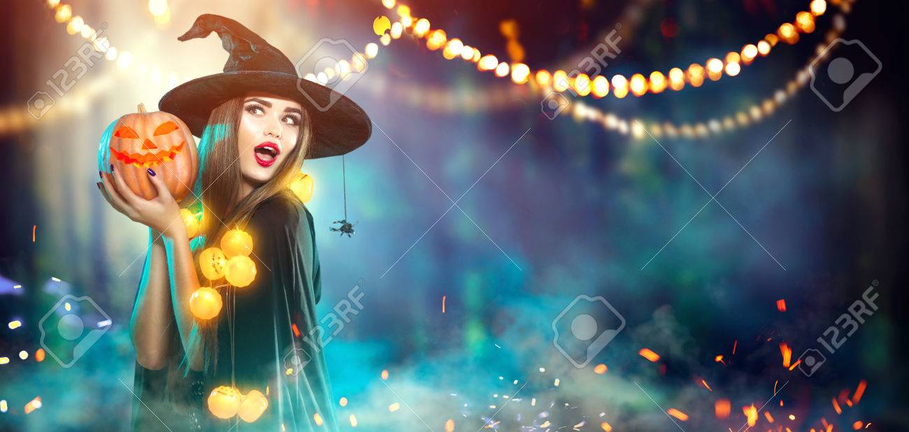 Halloween. Witch with a carved pumpkin and magic lights in a dark forest - 86272565 Halloween. Witch with a carved pumpkin and magic lights in a dark forest - 86272565