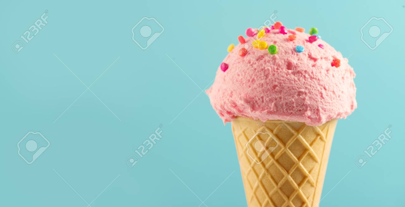 Ice cream. Strawberry or raspberry flavor icecream in waffle cone over blue background. Sweet dessert decorated with colorful sprinkles closeup - 102064228 Ice cream. Strawberry or raspberry flavor icecream in waffle cone over blue background. Sweet dessert decorated with colorful sprinkles closeup - 102064228