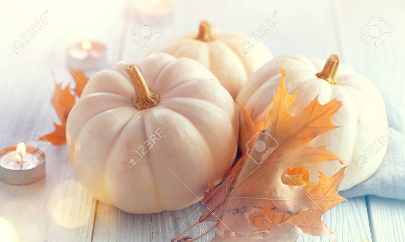 Thanksgiving background. Holiday scene. Wooden table, decorated with pumpkins, autumn leaves and candles - 112655373 Thanksgiving background. Holiday scene. Wooden table, decorated with pumpkins, autumn leaves and candles - 112655373