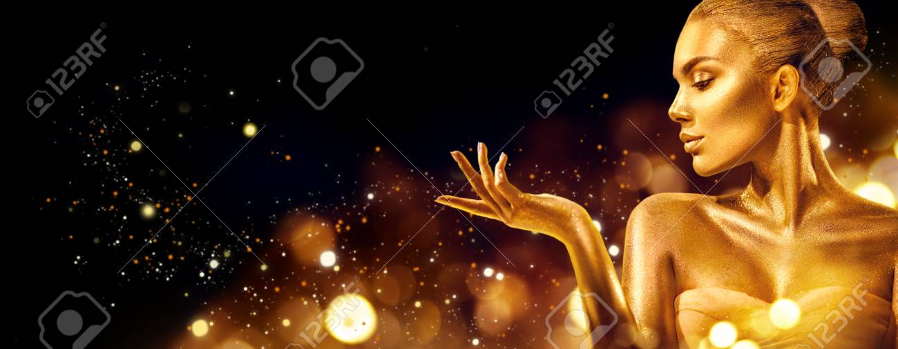 Gold Christmas woman. Beauty fashion model girl with golden makeup, hair and jewellery pointing hand on black background - 112144548 Gold Christmas woman. Beauty fashion model girl with golden makeup, hair and jewellery pointing hand on black background - 112144548