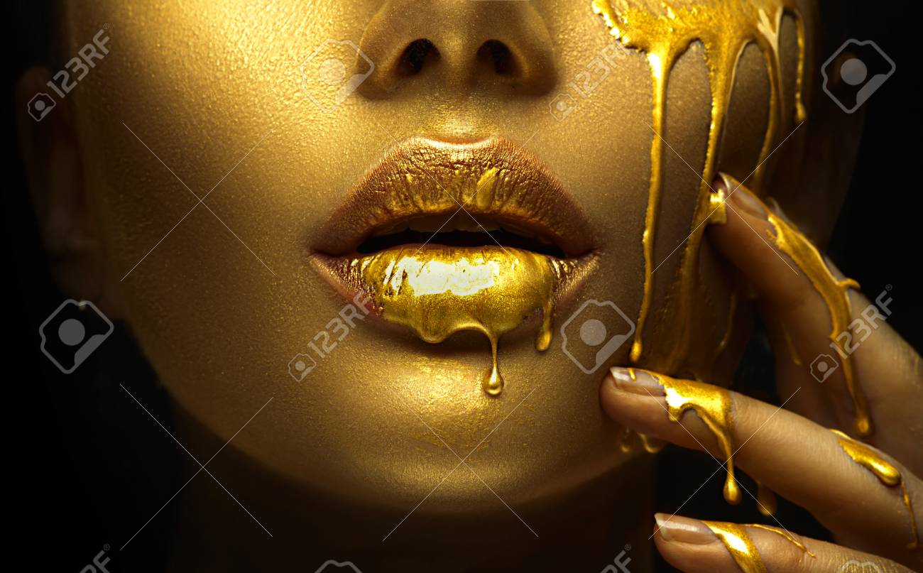 Golden paint smudges drips from the face lips and hand, golden liquid drops on beautiful model girl's mouth, creative abstract makeup. Beauty woman face - 113306865 Golden paint smudges drips from the face lips and hand, golden liquid drops on beautiful model girl's mouth, creative abstract makeup. Beauty woman face - 113306865