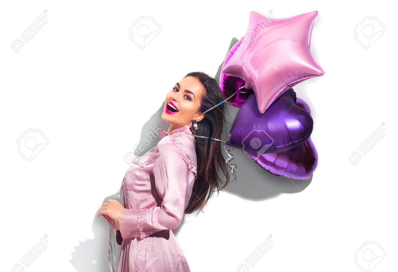 Beauty fashion model party girl with heart shaped air balloons having fun. Birthday party, Valentines Day. Beautiful young brunette woman over white background - 114389754 Beauty fashion model party girl with heart shaped air balloons having fun. Birthday party, Valentines Day. Beautiful young brunette woman over white background - 114389754