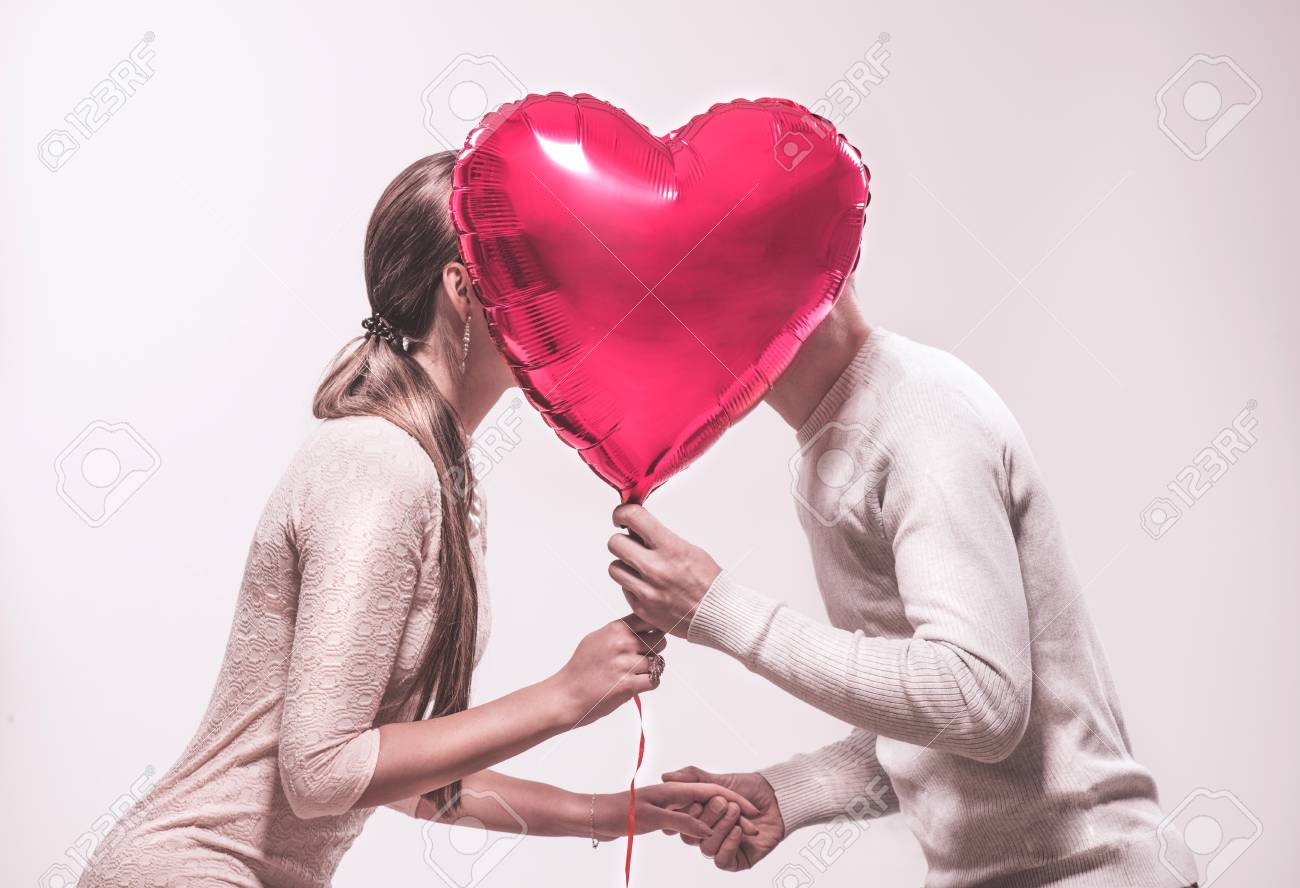 Valentine's day. Happy joyful couple holding heart shaped air balloon and kissing. Love. Happy Valentine's Day celebrating - 117555538 Valentine's day. Happy joyful couple holding heart shaped air balloon and kissing. Love. Happy Valentine's Day celebrating - 117555538