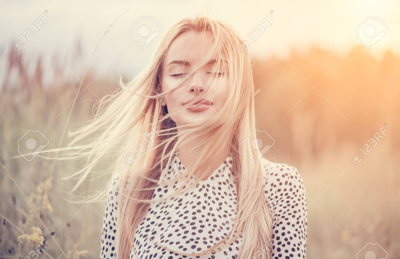 Close Up Portrait of beauty girl with fluttering white hair enjoying nature outdoors, on a field. Flying blonde hair on the wind. Breeze playing with girl's hair. Beautiful young woman face closeup - 131366170 Close Up Portrait of beauty girl with fluttering white hair enjoying nature outdoors, on a field. Flying blonde hair on the wind. Breeze playing with girl's hair. Beautiful young woman face closeup - 131366170