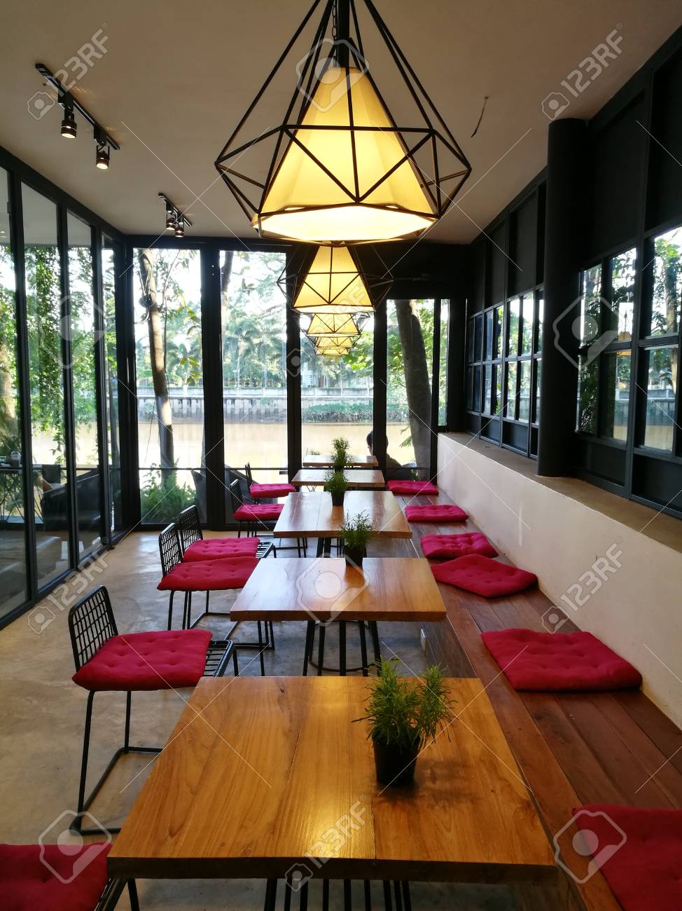 コーヒー ショップ インテリア モダンな居心地の良い天井ランプ 植物 赤い椅子木製のテーブルにコーヒー ショップ カフェ インテリア川ビュー ウィンドウで 北タイの飲食店のヒップスター ライフ スタイル コンセプト の写真素材 画像素材 Image