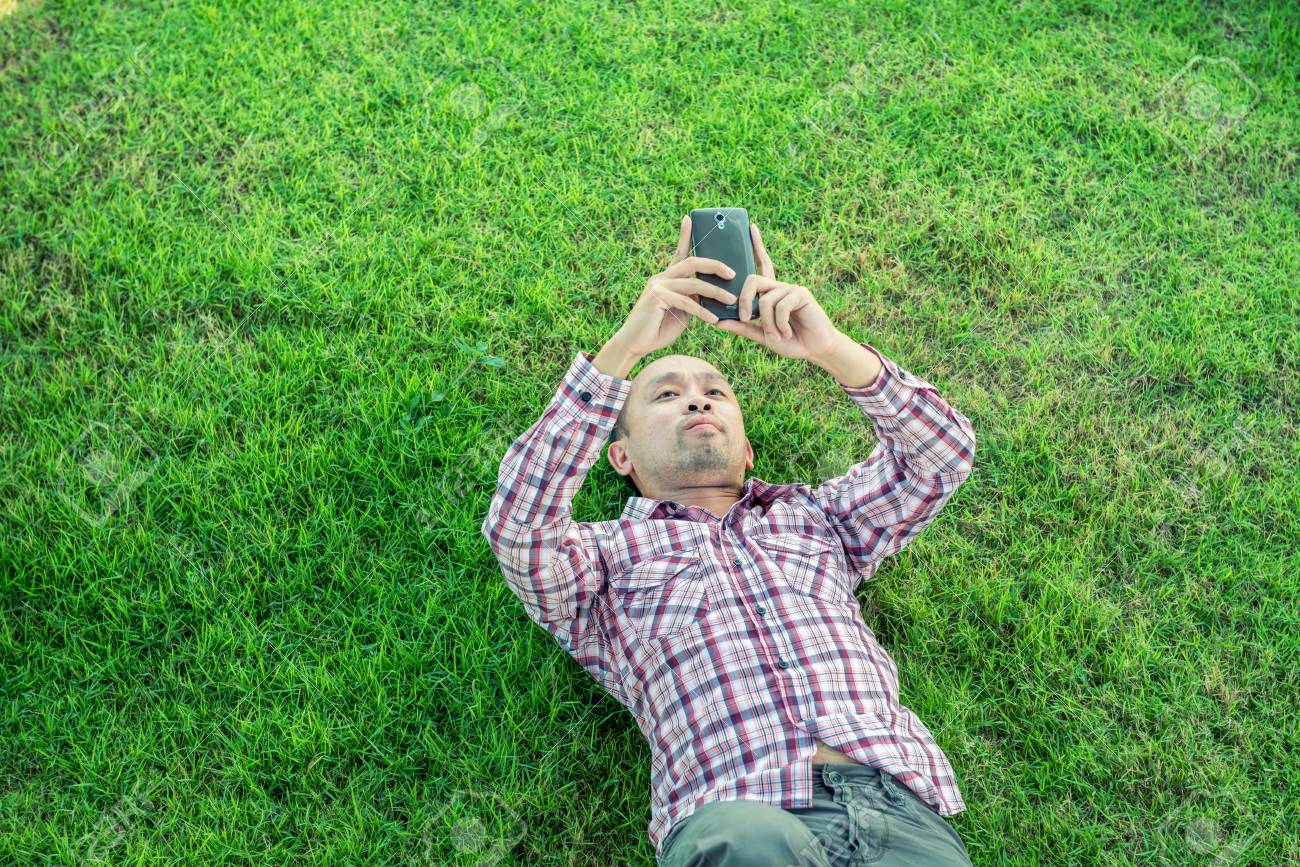 仰向けになって手でスマート フォンを使用して草男 の写真素材 画像素材 Image 仰向けになって手でスマート フォンを使用して草男 の写真素材 画像素材 Image