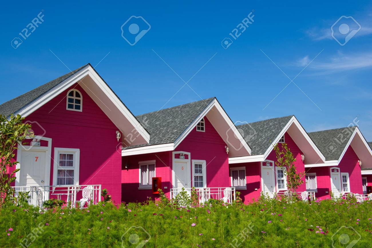 茶色の屋根と青い空が同じ行に接続する単一のピンクの家 の写真素材 画像素材 Image