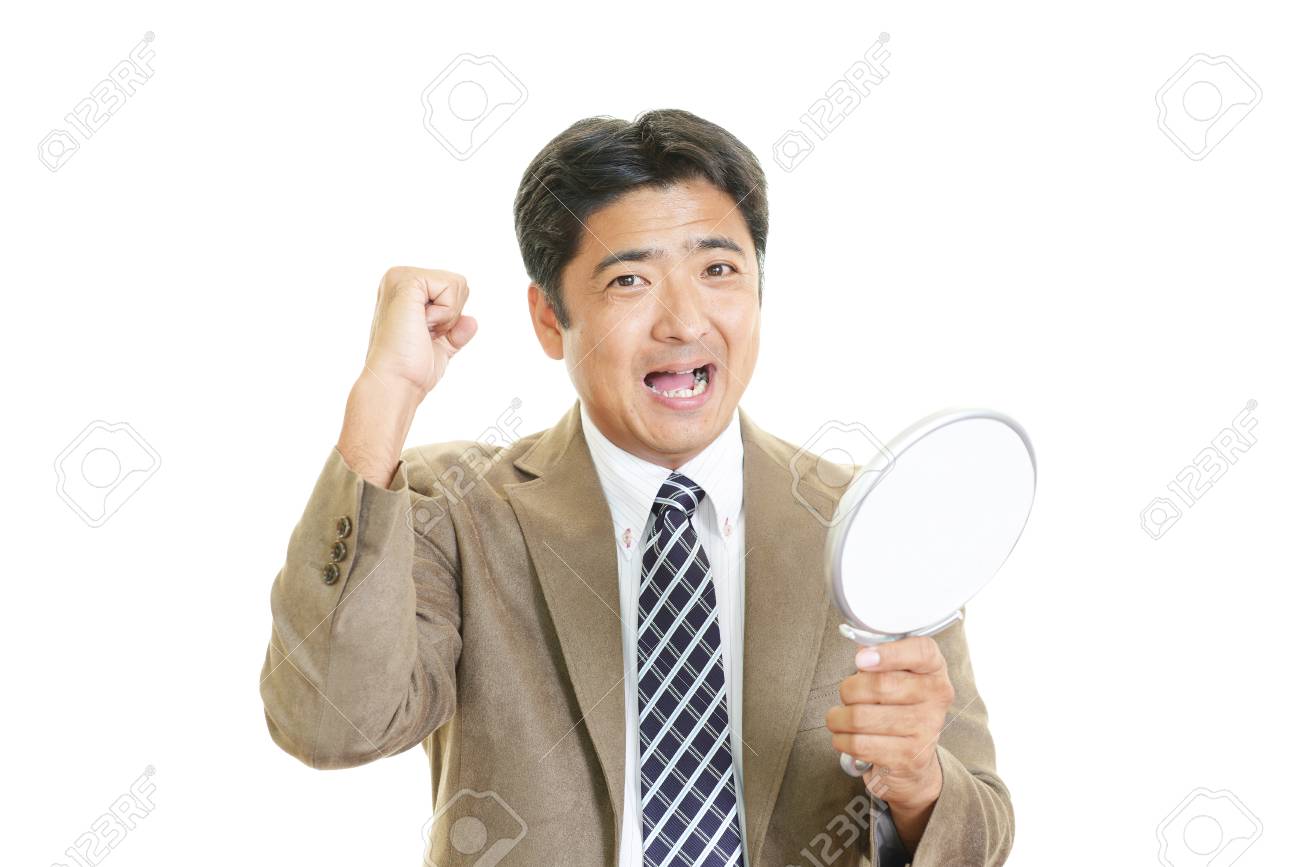 a man looking at himself in a hand mirror stock photo picture and