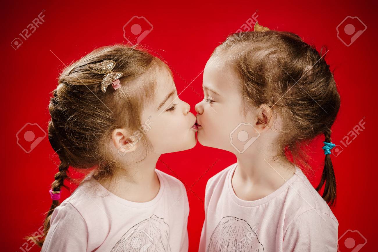 Two Beautiful Twin Sisters Give Each Other A Kiss Stock Photo, Picture and  Royalty Free Image. Image 70376977.