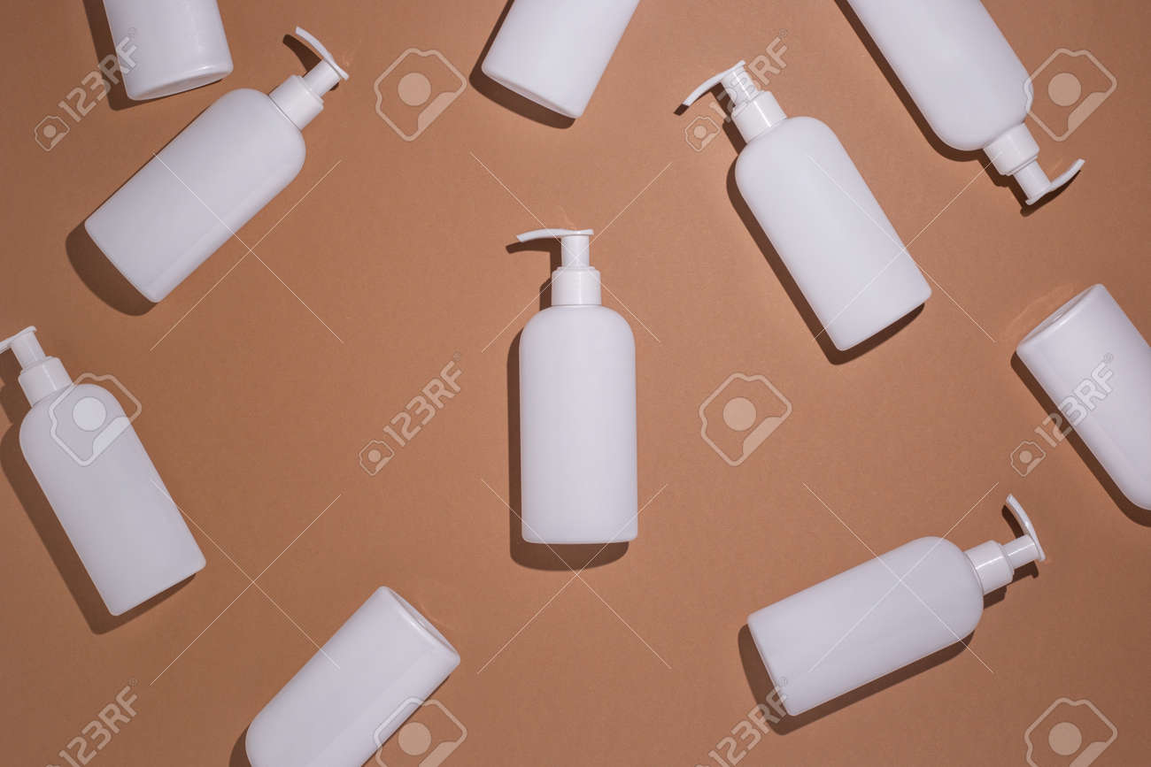 White bottles with a dispenser lie on a brown cardboard background. Top view, flat lay. - 171847639 White bottles with a dispenser lie on a brown cardboard background. Top view, flat lay. - 171847639