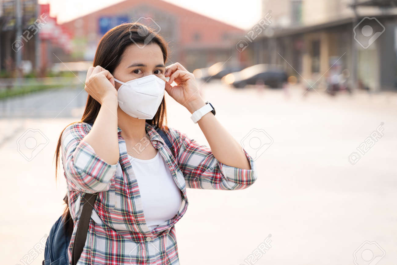 Asian woman wearing N95 face mask to protect pollution PM2.5 and virus. COVID-19 Coronavirus and Air pollution pm2.5 Healthcare and medical concept. - 171949183 Asian woman wearing N95 face mask to protect pollution PM2.5 and virus. COVID-19 Coronavirus and Air pollution pm2.5 Healthcare and medical concept. - 171949183
