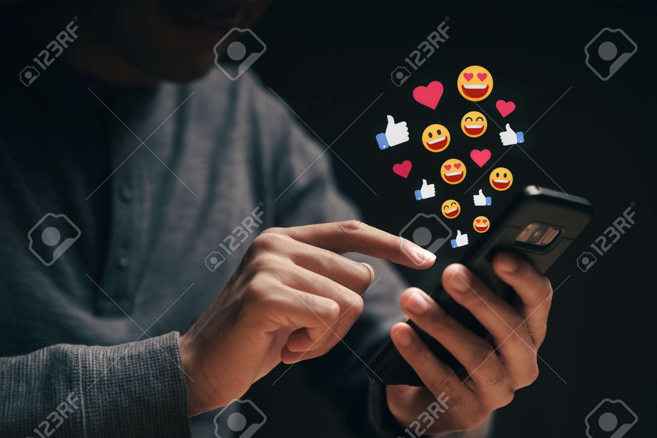 Happy young man using smartphone chatting on Social network sending Emoji, Emoticon. Social media, Live Streaming Concept. - 172263054 Happy young man using smartphone chatting on Social network sending Emoji, Emoticon. Social media, Live Streaming Concept. - 172263054